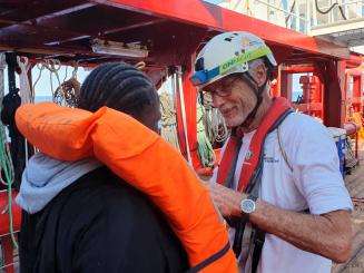 Medical Team Leader, Stefanie, helps rescued people remove their life jackets as they come on board Ocean Viking.