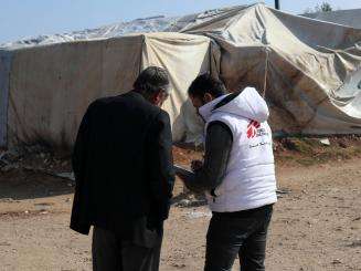 An MSF health worker talks with a Syrian man in Qadimoon camp.