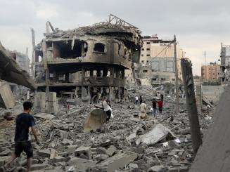 People walk across the wreckage left by Israeli airstrikes in Gaza in October 2023.