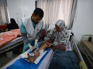 An MSF staff member treats a patient at Rafah Indonesian Field Hospital in Gaza