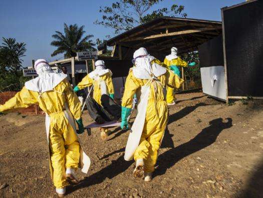 MSF staff transport a person who may have Ebola from an ambulance that broke down before reaching the MSF Ebola management center in Kailahun, a three-hour drive from the patient’s home. 