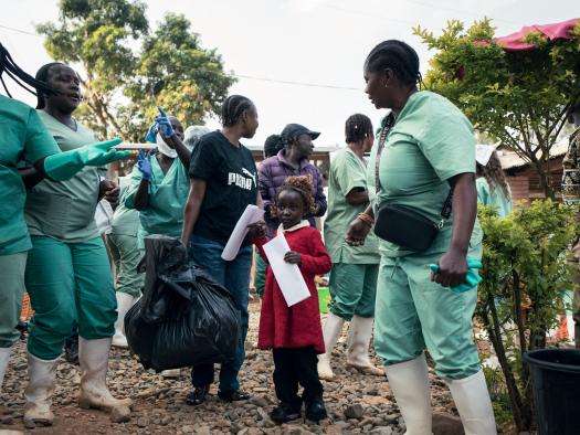 Hospital staff sing and applaud as Florence and 3-year-old Furaha are discharged from MSF's Ebola treatment center after recovering from the disease.