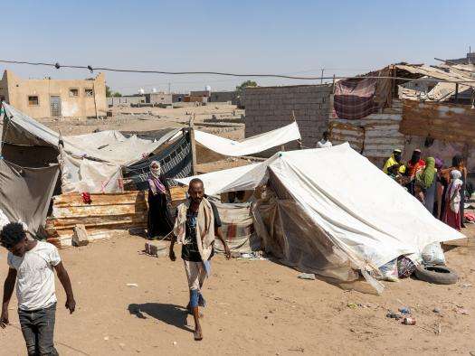 People walk in a displacement camp in Yemen. 