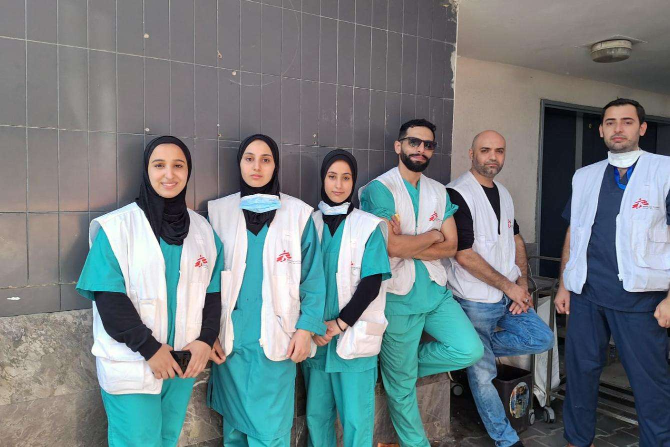MSF staff in scrubs and white vests outside Al Shifa Hospital in Gaza on October 24.