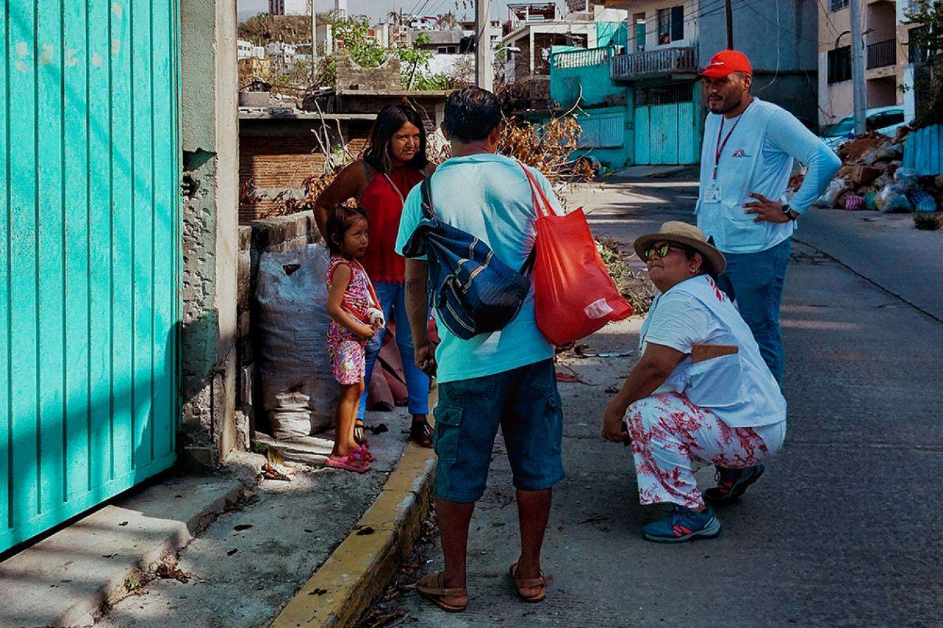People with backpacks in hurricane-damaged Acapulco, Mexico.