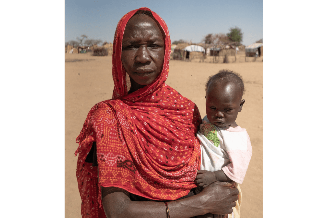 A refugee woman holding her child in a camp in Chad.