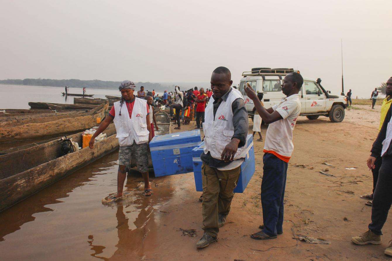  MSF team members unload insulated containers of measles vaccine