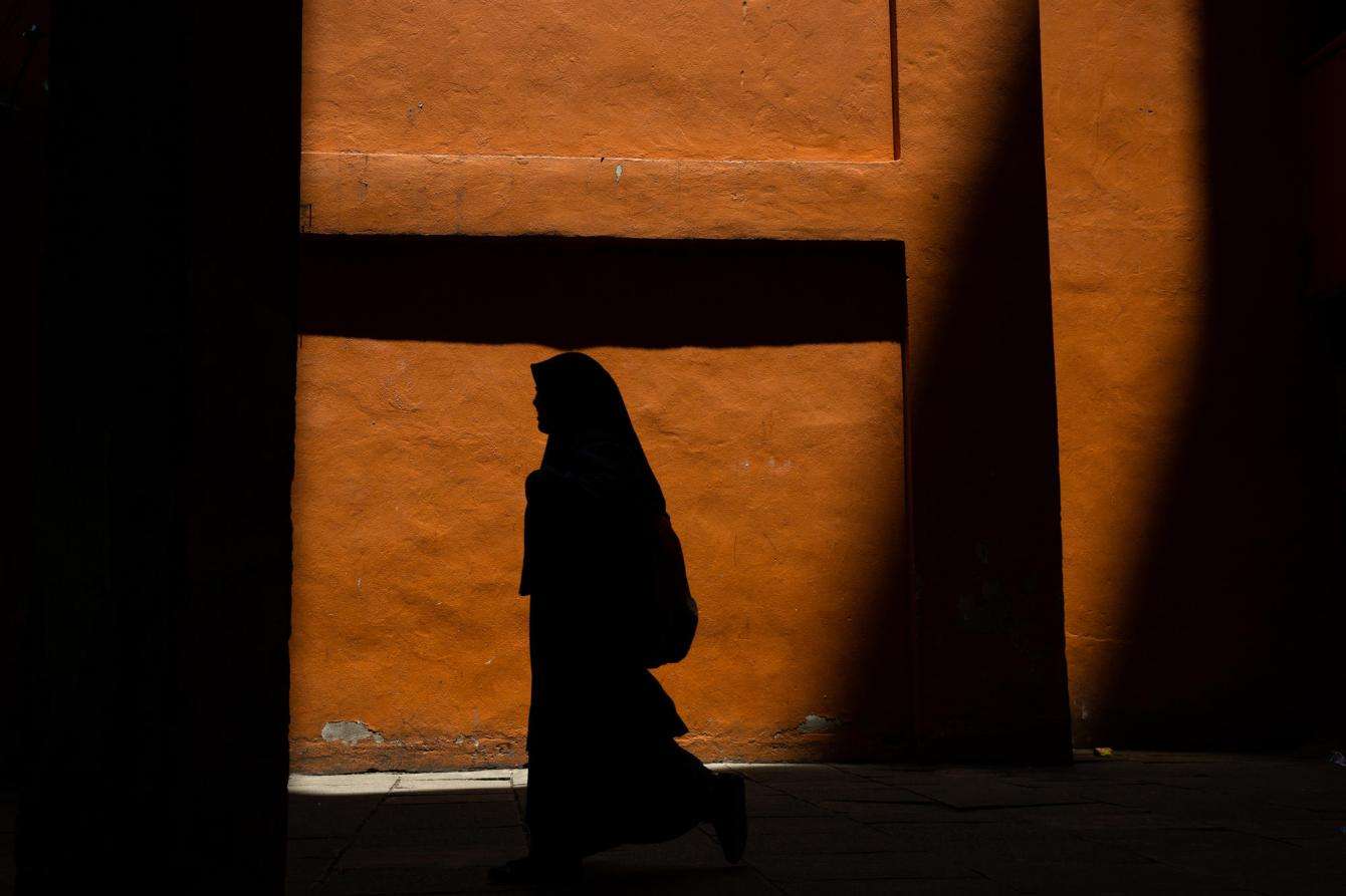 The shadow of a young Rohingya girl walking to the mosque for Friday prayer in Malaysia.