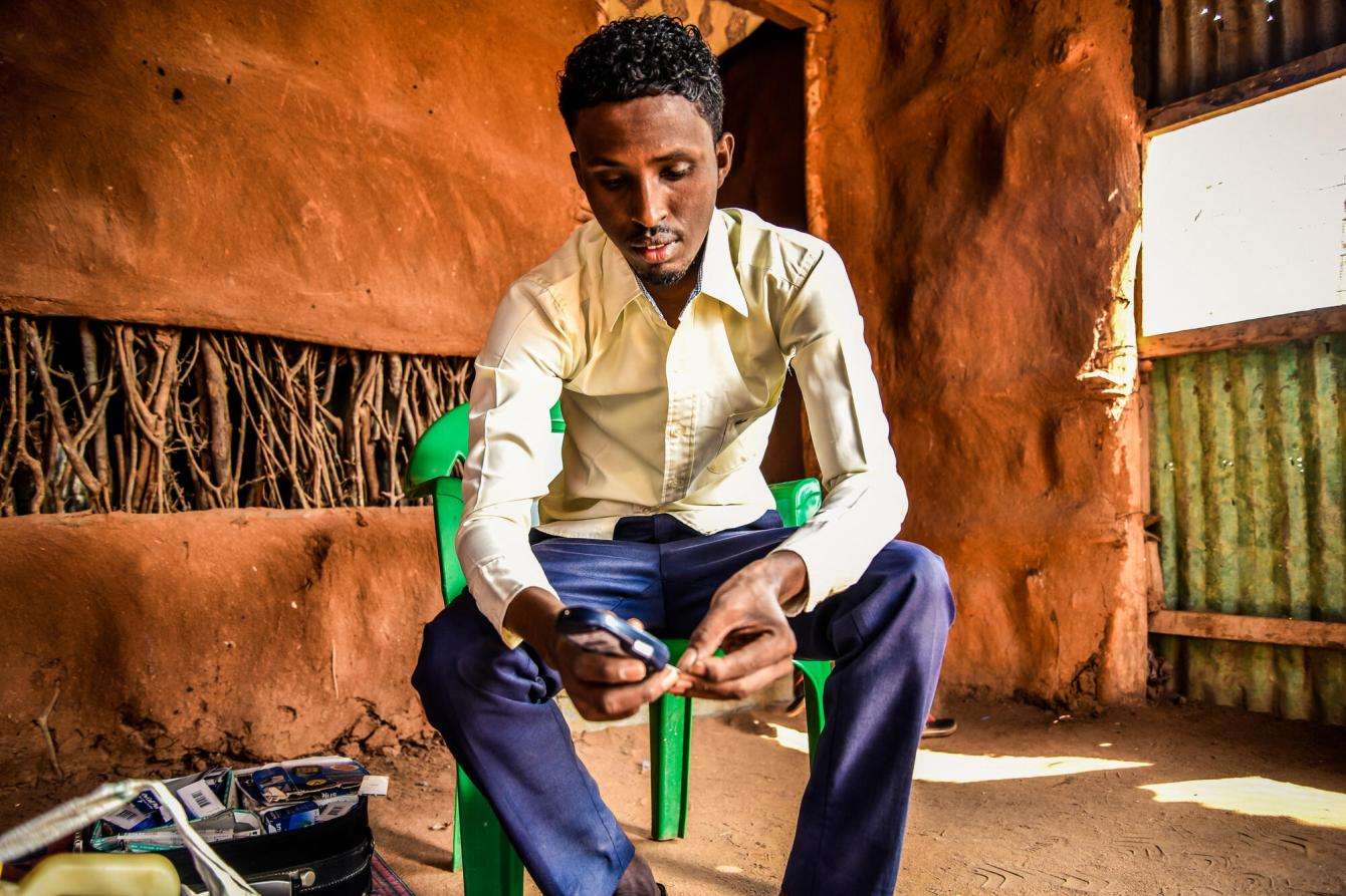 Mohamed Hussein Bule, 27, who lives with Type 1 diabetes, holds his insulin pen.