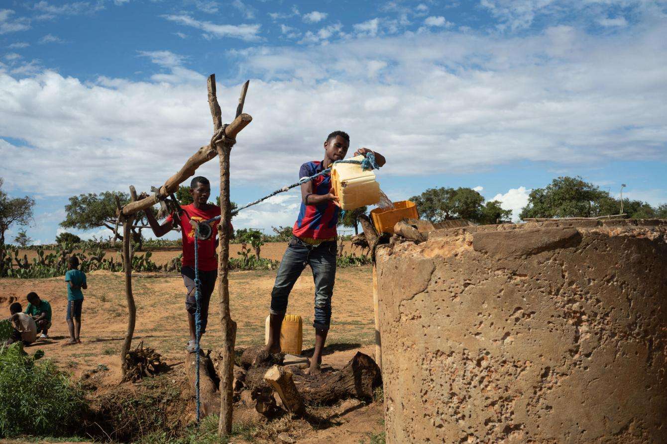 A young man fetches water from a well in the desert of Madagascar.