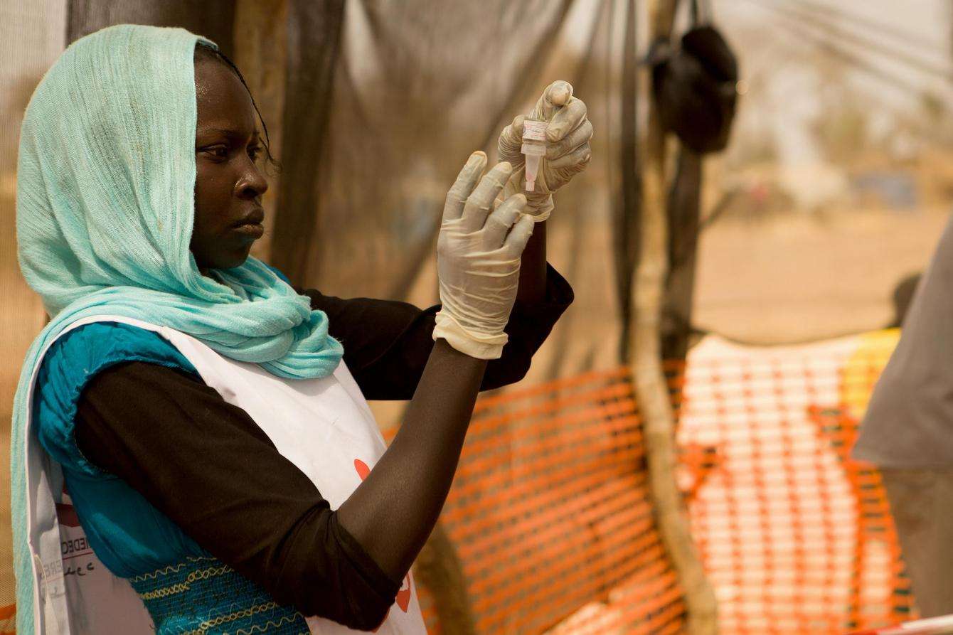 An MSF team member prepares a dose of polio vaccine