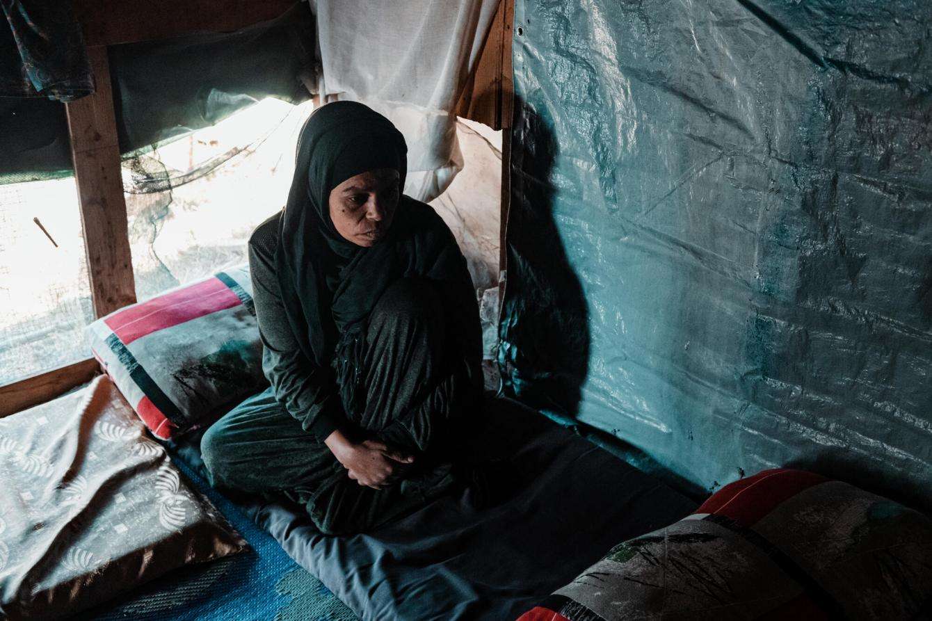 Woman sits in a dark tent