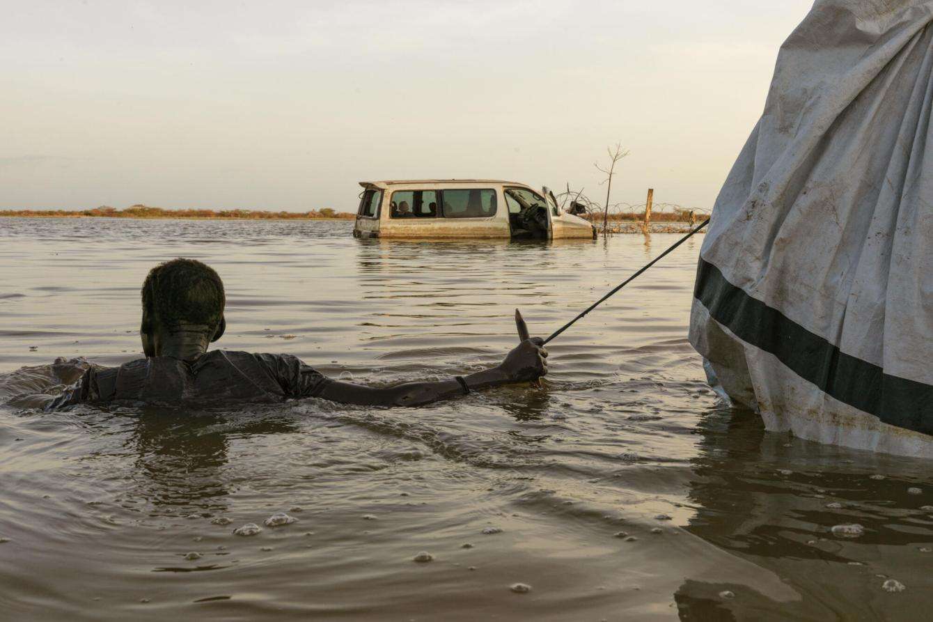 Man carries belongings through flood waters