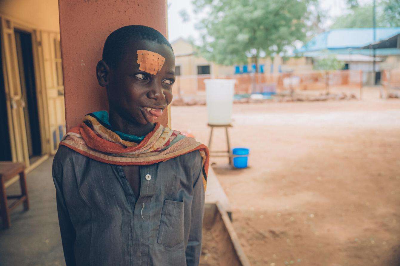 A young boy who is a noma survivor in the courtyard of Sokoto Noma Hospital in Nigeria