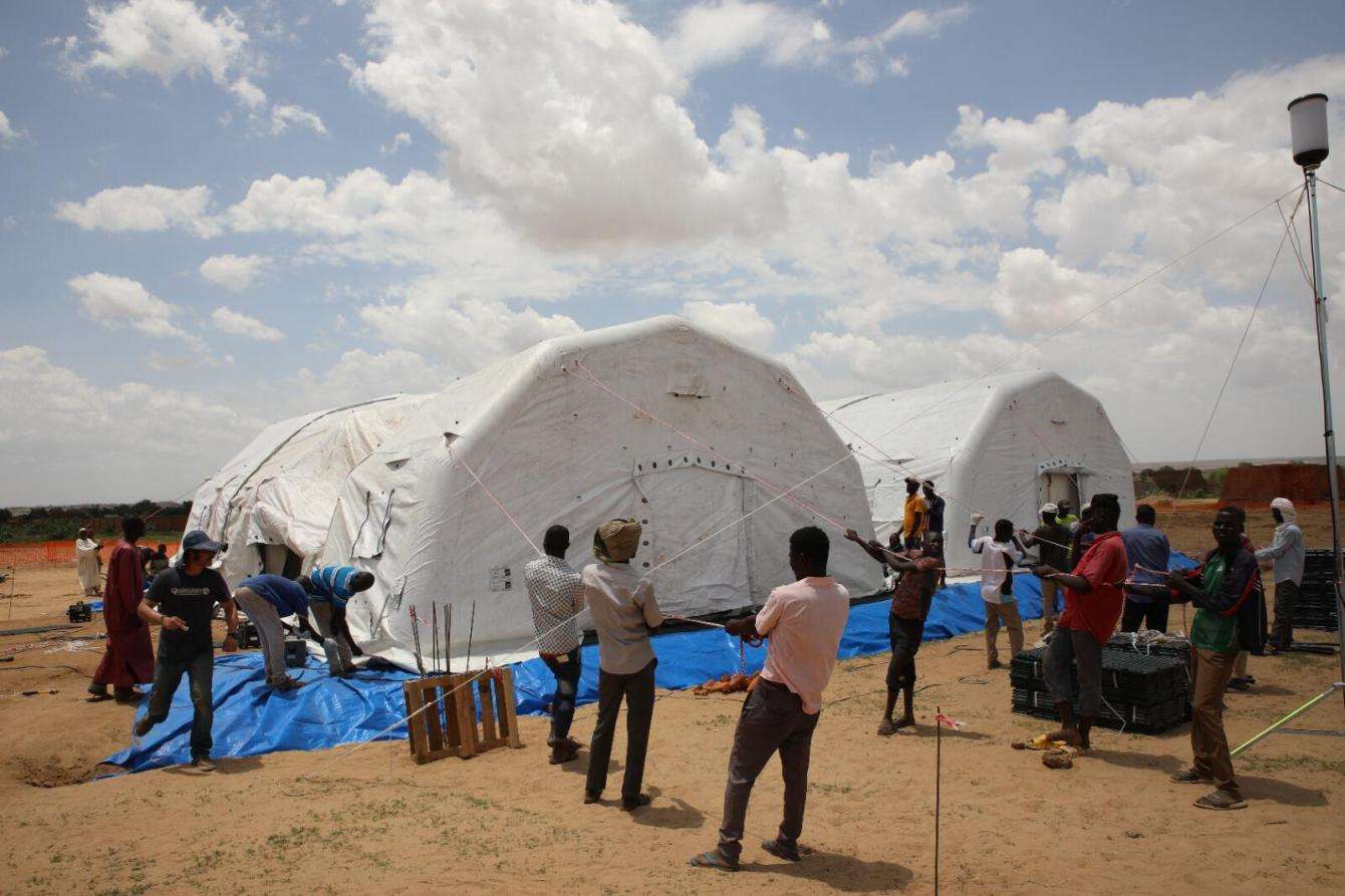 MSF aid workers stand in front of an inflatable tent hospital for Sudanese refugees in Adre, Chad 