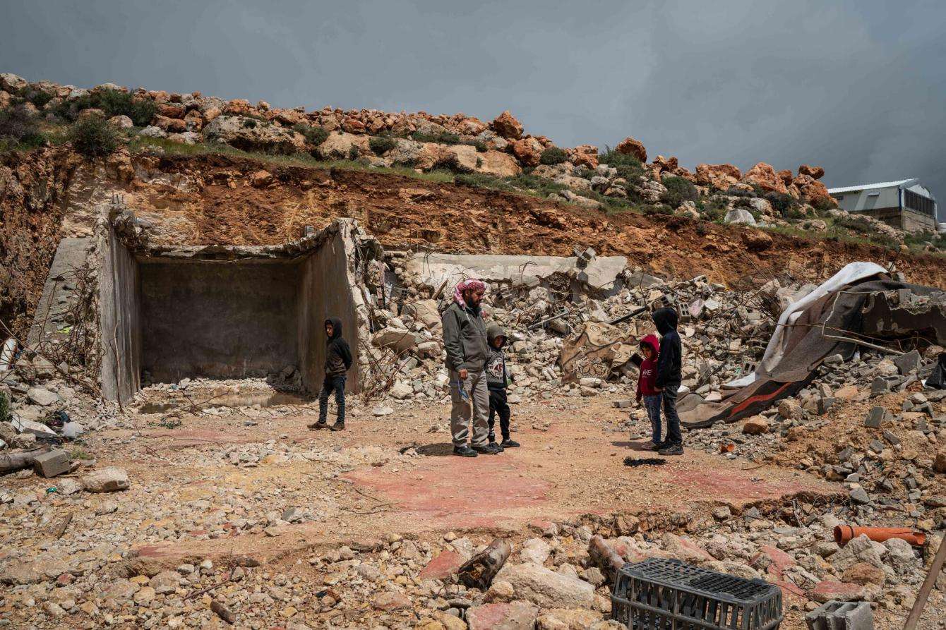A Palestinian Bedouin family looks at the ruins of their home after Israel demolished it in the West Bank.