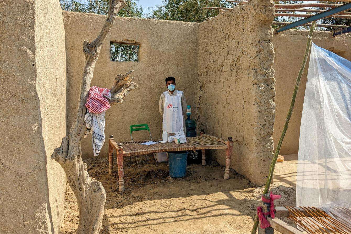 A man standing in a roofless stone structure that serves as an MSF clinic in Dadu district, Pakistan.