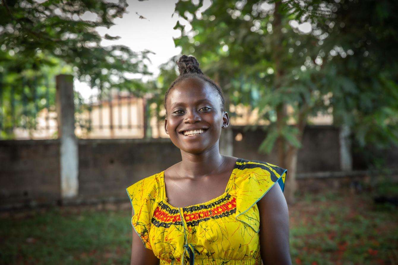 young woman in a yellow dress standing outside in Central African Republic