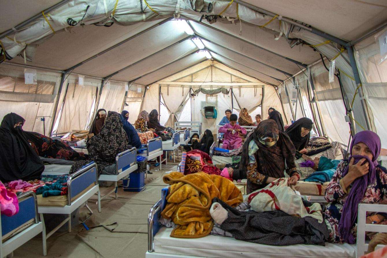 A group of women survivors of the October 15 earthquake in Afghanistan sit under a tent.