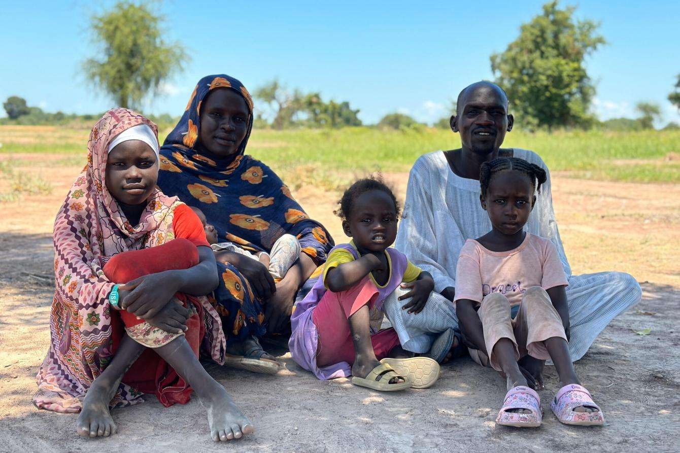 Musa Abakar Juma and Alima Adushafa sitting with children