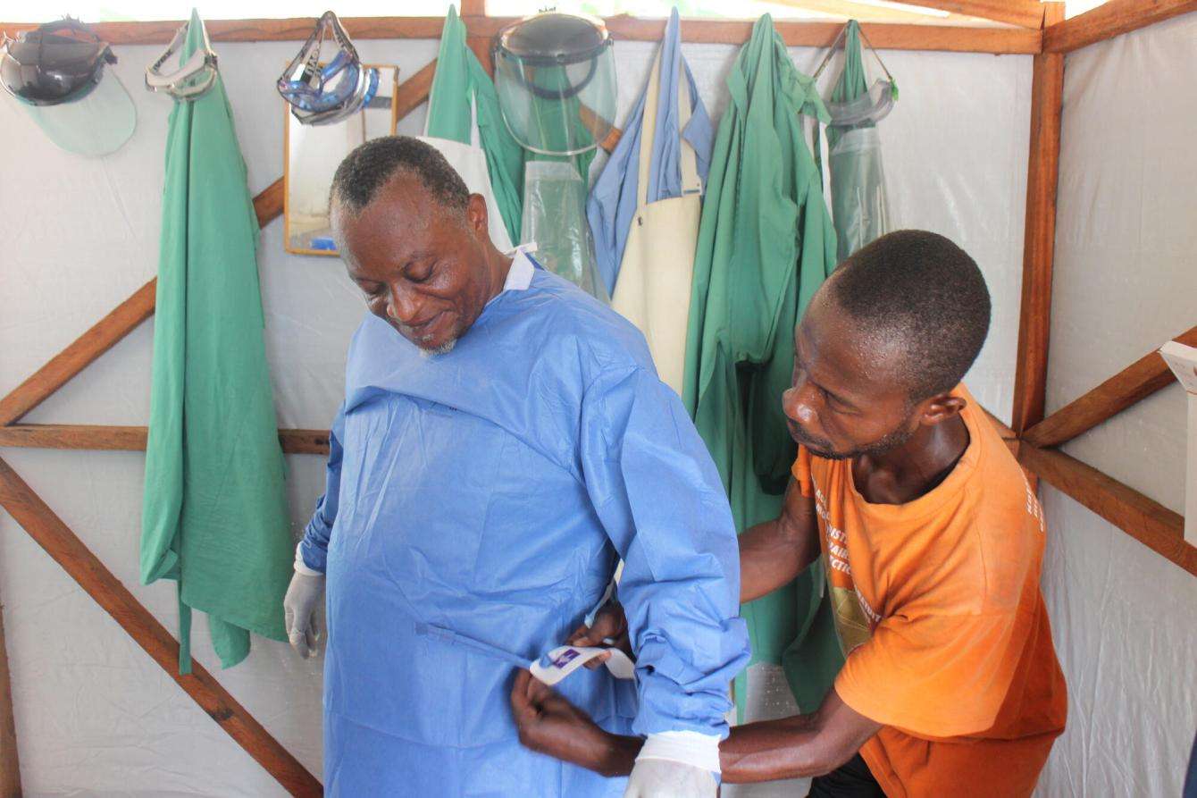 A physician at Bolomba General Referral Hospital, puts on protective equipment before entering the Mpox patient unit.