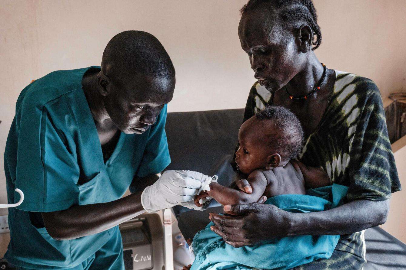 A nurse aid checks a child patient at the emergency room of Ameth Bek Hospital in Abyei, South Sudan.