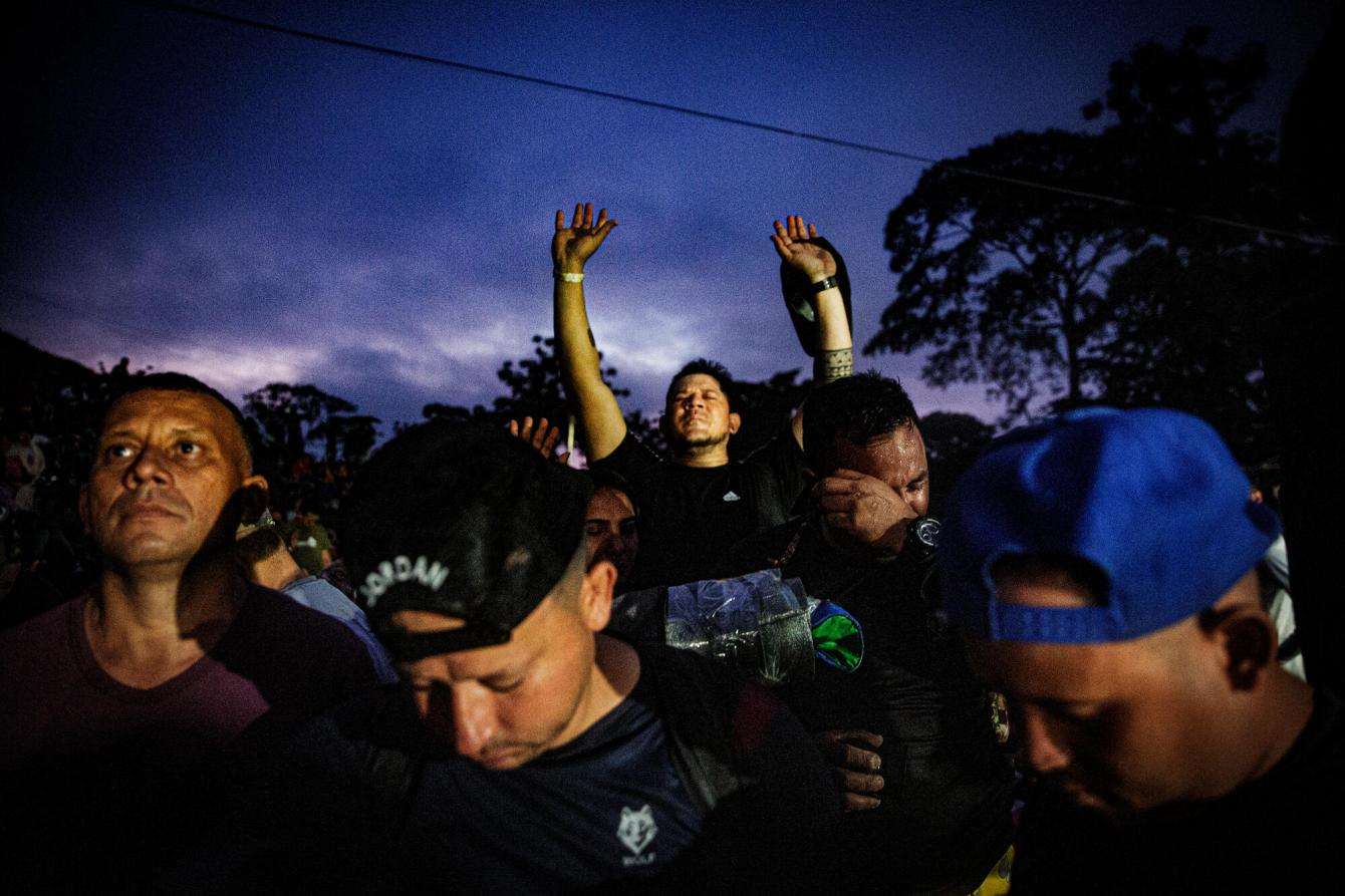 Migrants pray while waiting for the sunrise to enter the Darién jungle between Colombia and Panama.