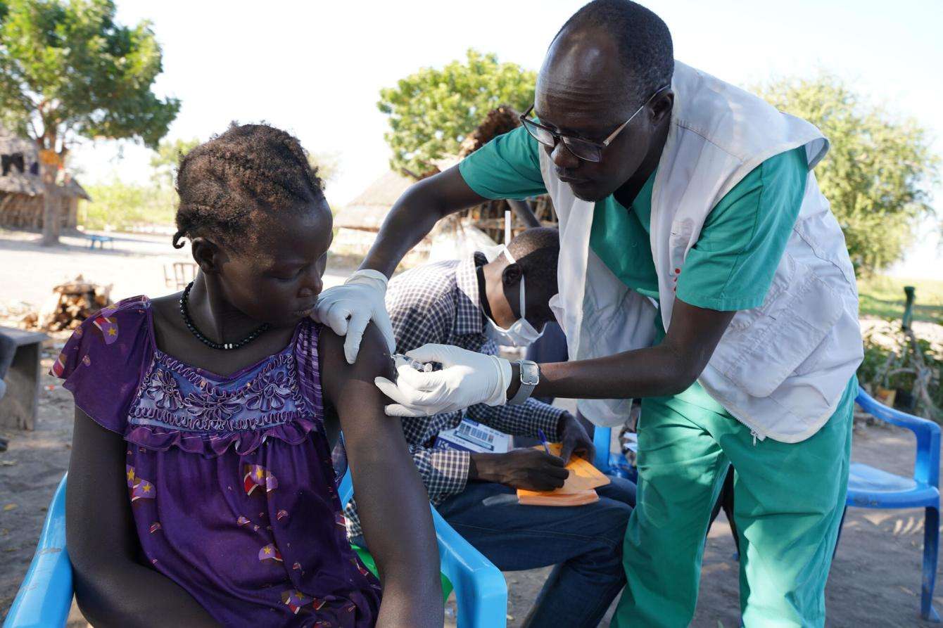 MSF nursing team supervisor Bang Bol administers the first dose of the Hepatitis E vaccine to a woman in Wangmok village, Jonglei state. 