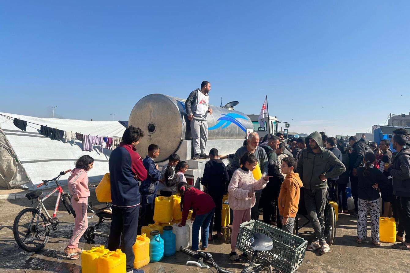 Youssef Al-Khishawi, an MSF water and sanitation agent, oversees a water distribution from the platform of an MSF truck in the Tal Al-Sultan area of the southern Gaza town of Rafah.