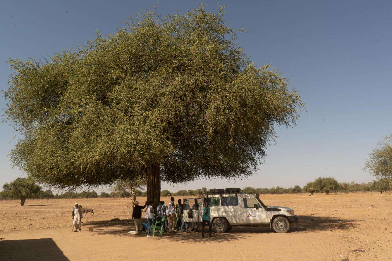 The MSF team unloads supplies under a tree to set up a mobile clinic in Chad.