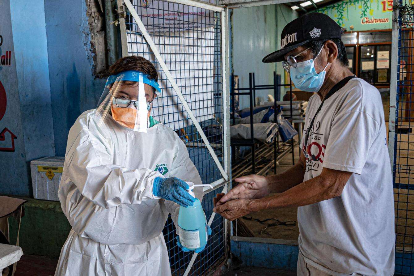 Tony, 69, disinfects his hands with hand sanitizer after submitting his sputum sample at the MSF mobile TB screening site in Manila, Philippines.