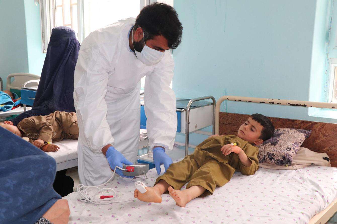 An MSF nurse checks the vital signs of five-year-old Hamid in the measles isolation ward supported by MSF at Mazar-i-Sharif Regional Hospital in Balkh province, Afghanistan.