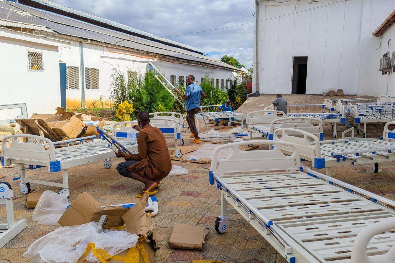 MSF staff move beds through a courtyard in Somalia. 