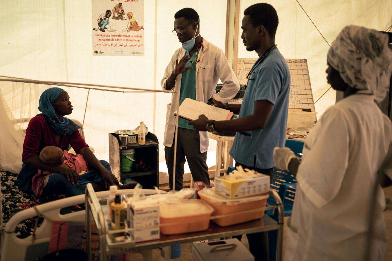 Doctors and nurses at the MSF-run inpatient therapeutic feeding center in Adré explain the next steps of treatment for Halima's 20-month-old son, Nassier, who has severe acute malnutrition with complications.