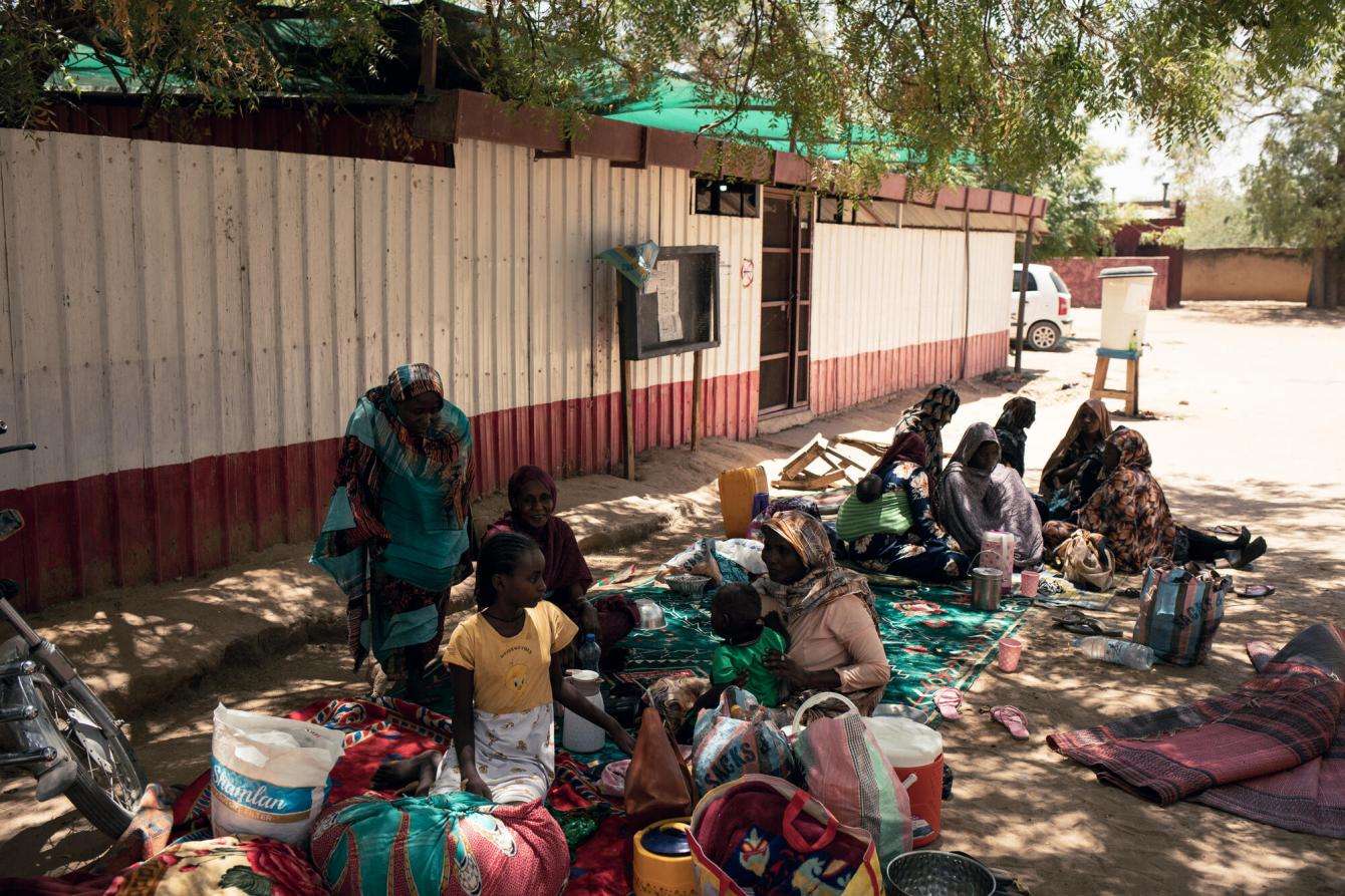 Caregivers and children wait outside a clinic in Adré, Chad. 