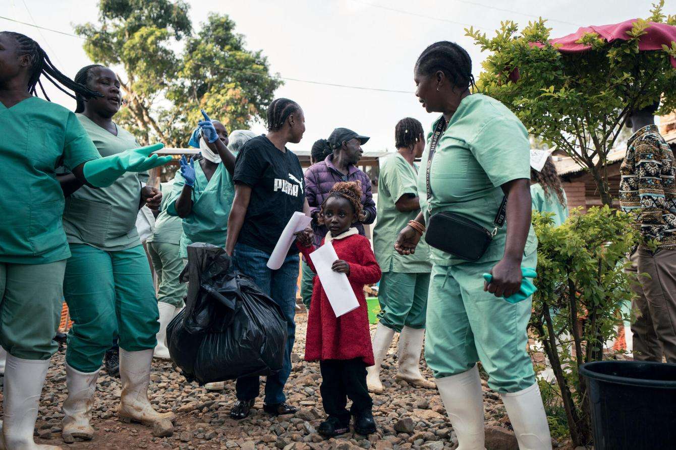 Hospital staff sing and applaud as Florence and 3-year-old Furaha are discharged from MSF's Ebola treatment center after recovering from the disease.
