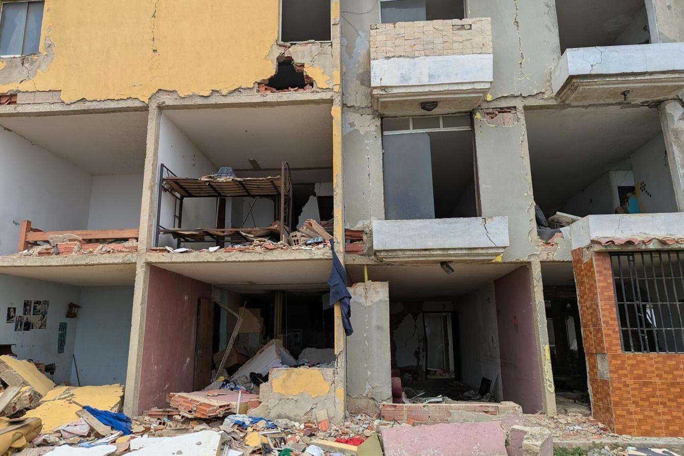 Scattered clothes, photos, and furniture remain inside a ruined building in Playa Verde, Venezuela.