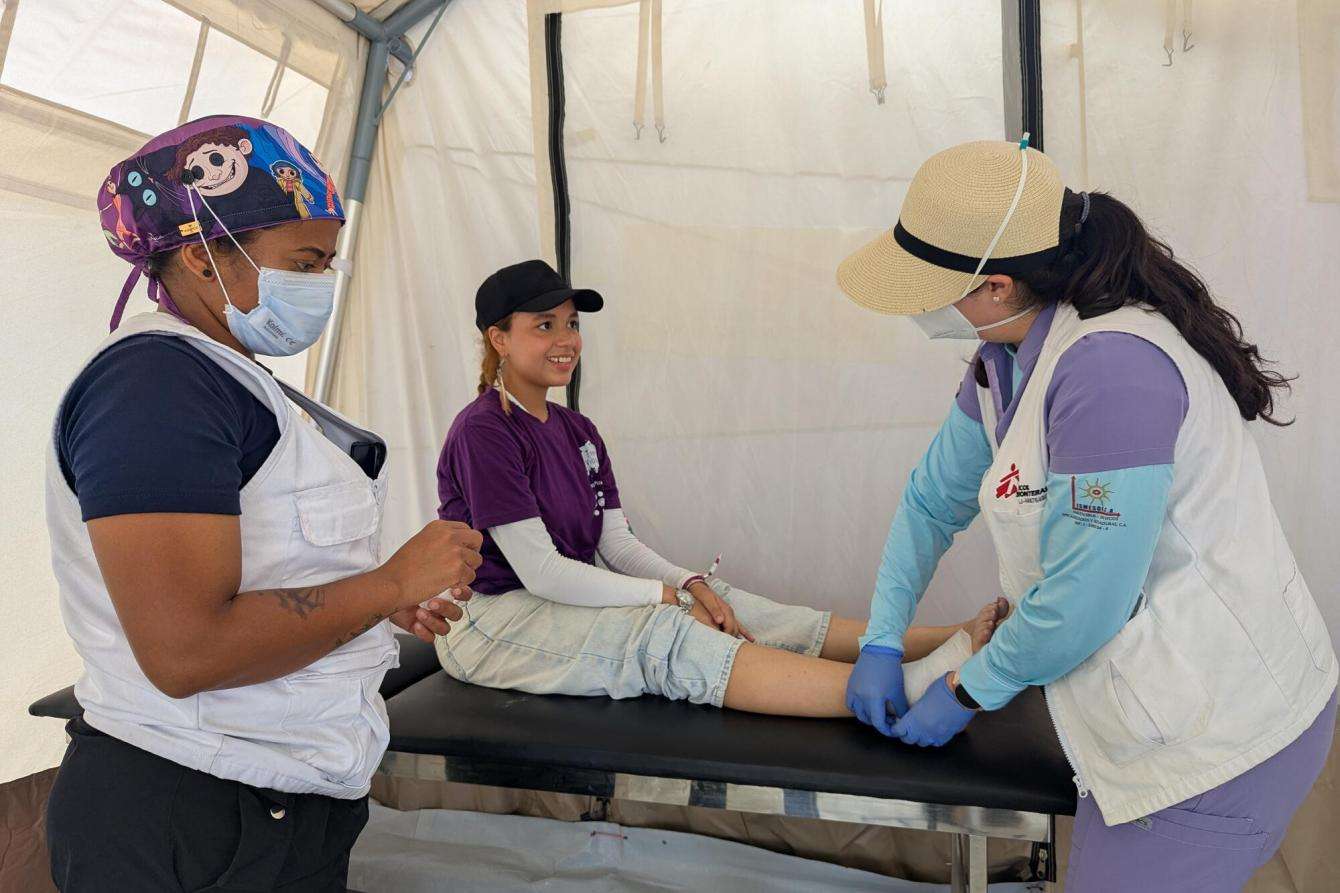 Dr. Gloria bandages a patient, Samira, at an MSF mobile clinic in Playa Verde on July 21.