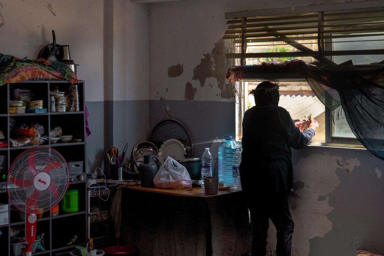 A displaced woman in the kitchen of a shelter in Jiyeh, Lebanon.