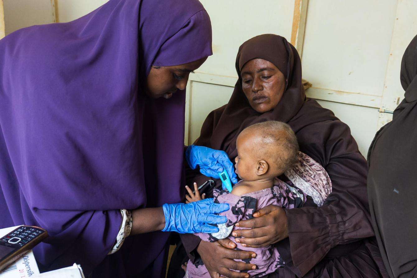 Nurse Hawa Hassan takes the temperature of a patient in Baidoa, Somalia
