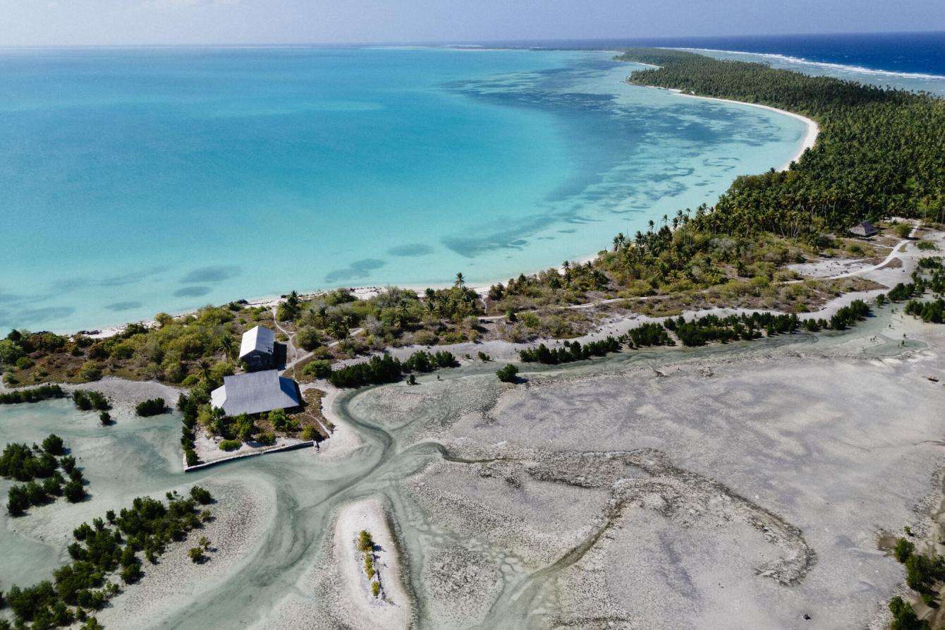 An aerial view of Tebunginako, a village on Abaiang Island that was abandoned by its residents due to saltwater intrusion, which caused land erosion and diminished freshwater sources. 