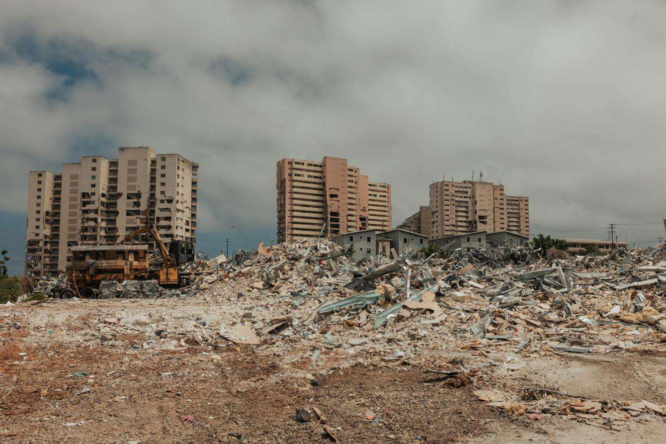Damaged buildings stand over the remains of a destroyed housing complex in Venezuela.