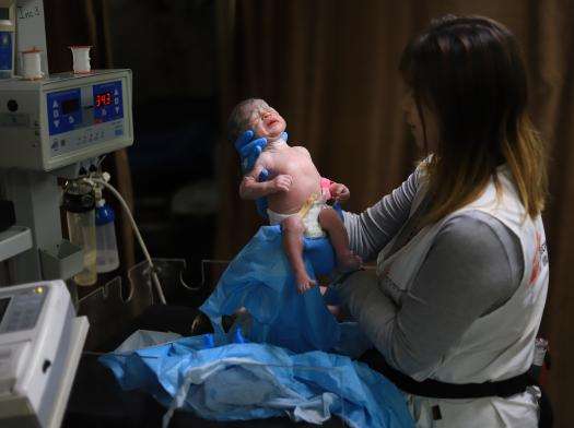 MSF midwife activity manager Hin So checks on a newborn baby at Nasser Hospital.