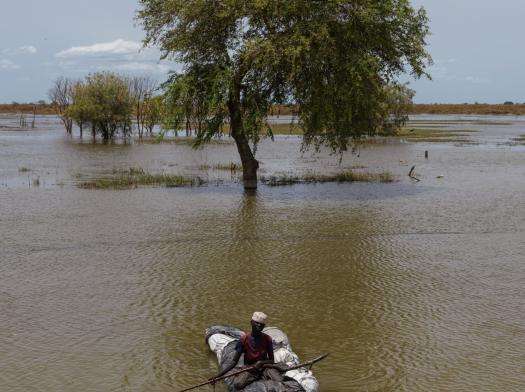 Man on makeshift boat in flood waters