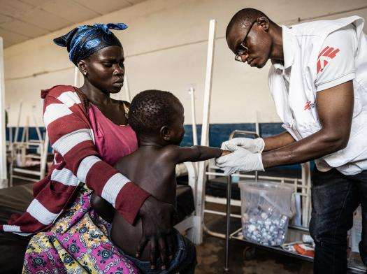 A mother holds her child as he gets a shot for fever and infection by Doctors Without Borders staff in Ituri, Democratic Republic of Congo (DRC).
