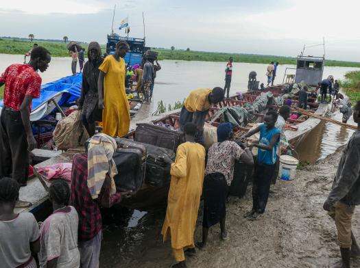 Returnees offloading their luggage from a boat in Bulukat port