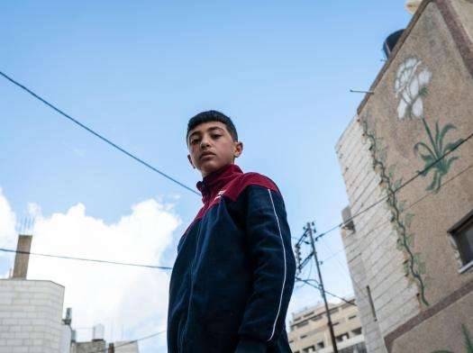 Hussam Odeh, a Palestinian boy, poses in the street near his home in Huwarra, West Bank, Occupied Palestinian Territories.