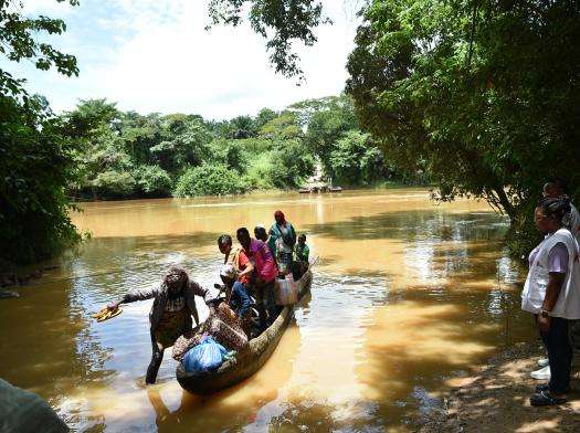 People getting out of a canoe after crossing the Rokel river, at Komrabai, Tonkolili District, Northern province of Sierra Leone.