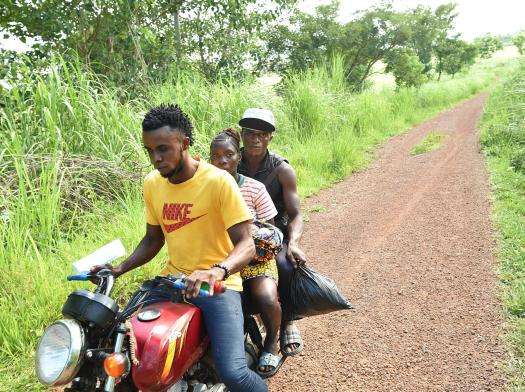A pregnant woman and her brother in law travel by motorcycle to reach maternal health care in Sierra Leone.