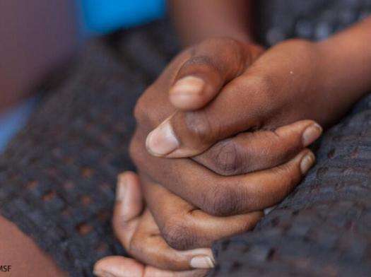 Close up of a woman's hands clasped on lap as she waits for safe abortion care